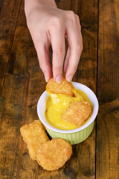 Hand mit Nuggets in Sauce — Stockfoto