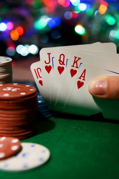 Fichas y cartas para póquer en mano sobre mesa verde —  Fotos de Stock