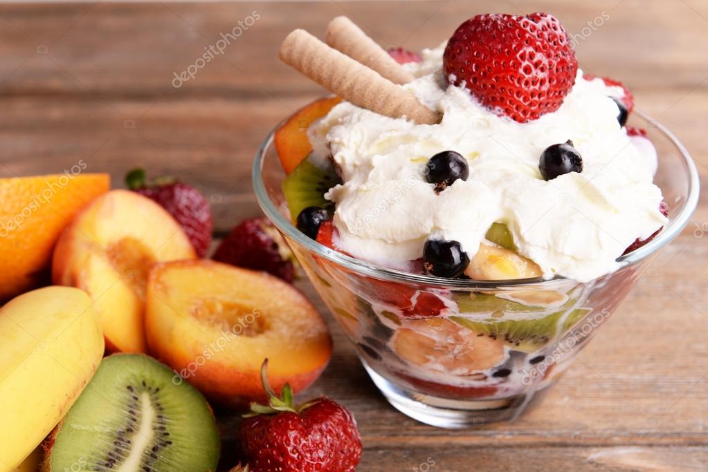 Fruits salad with ice cream in bowl and fruits