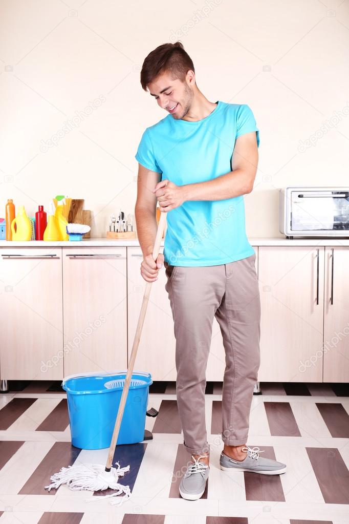 Young man cleaning floor