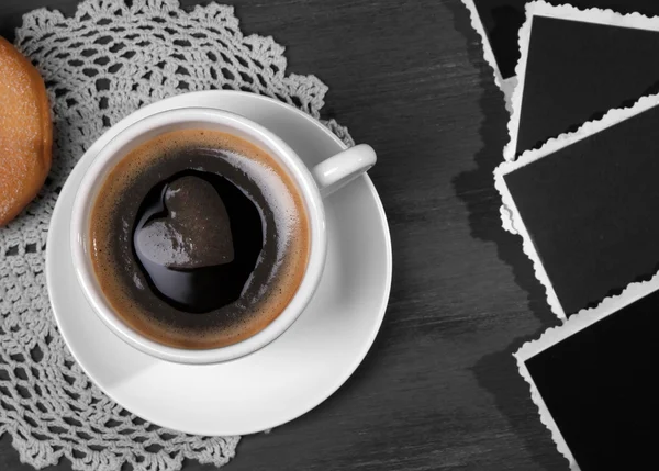 Taza de café, rosquilla y viejas fotos en blanco, sobre mesa de madera —  Fotos de Stock