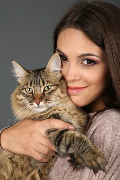 Mulher bonita segurando gato no fundo cinza — Fotografia de Stock