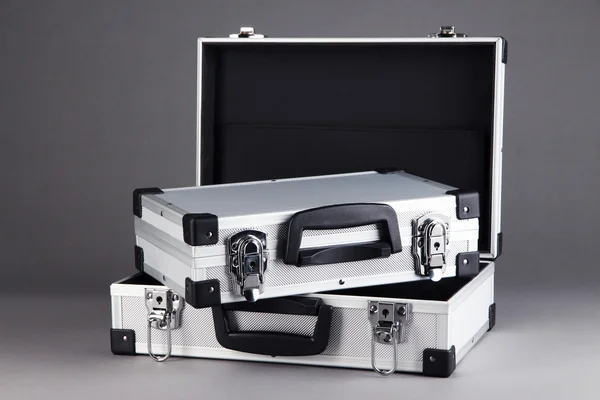 Silvery suitcases on grey background — Stock Photo, Image