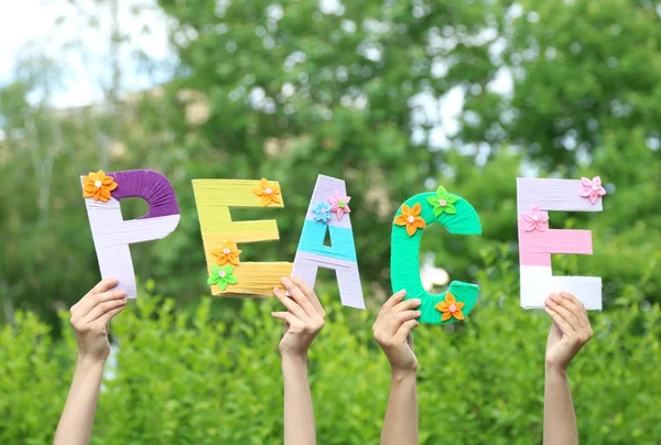 Hands holding up letters building word peace — Stock Photo, Image