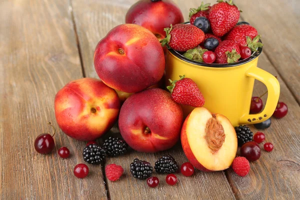 Peaches with berries on table — Stock Photo, Image