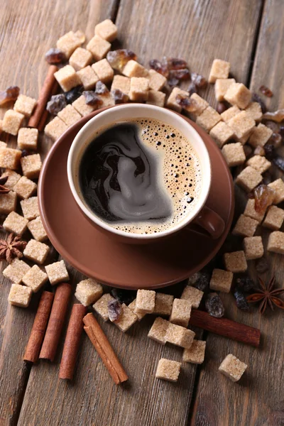 Açúcar mascavo, especiarias e xícara de café em fundo de madeira — Fotografia de Stock