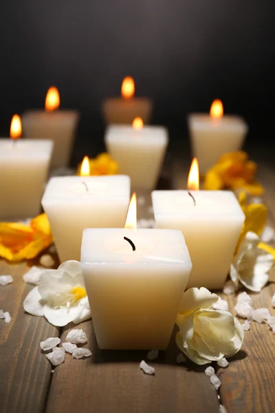 Beautiful candles with flowers on wooden background Royalty Free Stock Images