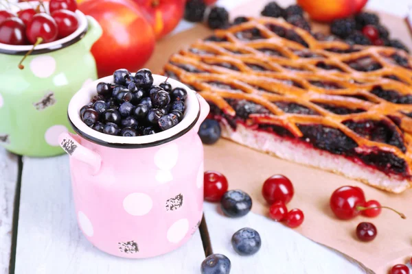 Sweet berries and berry tart on table close-up — Stock Photo, Image