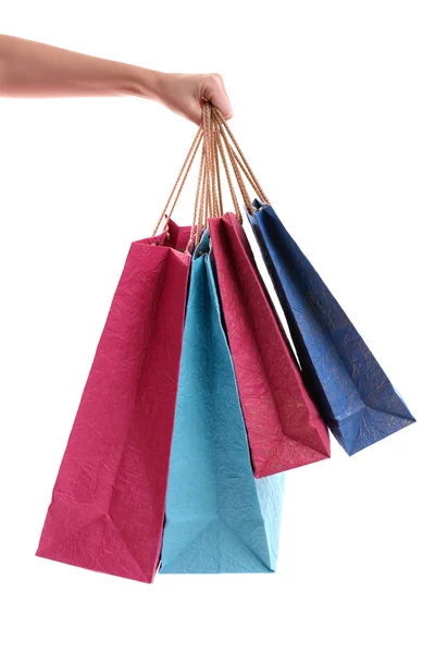 Mão feminina segurando sacos de compras de papel isolado no branco — Fotografia de Stock