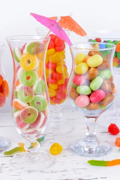 Different colorful fruit candy in glasses on table on light background — Stock Photo, Image