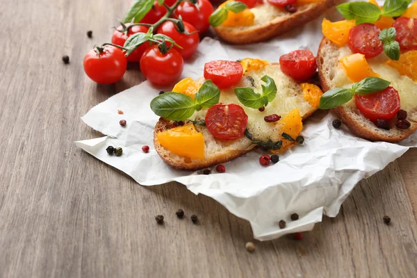 Läcker bruschetta med tomater, på gamla träbord — Stockfoto