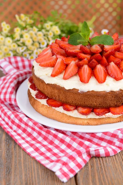 Délicieux gâteau aux biscuits aux fraises sur table sur fond brun — Photo