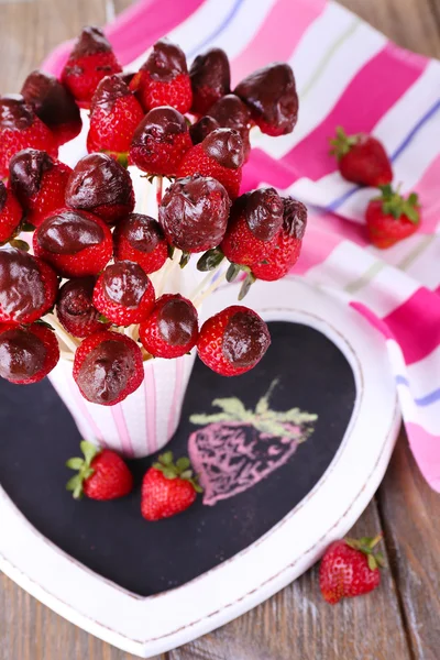 Strawberry in chocolate on skewers in cup on table close-up — Stock Photo, Image