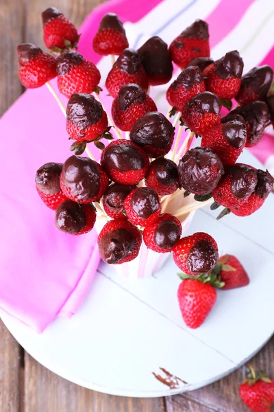 Strawberry in chocolate on skewers in cup on table close-up — Stock Photo, Image