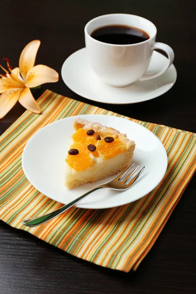 Piece of homemade orange tart on plate, on color wooden background — Stock Photo, Image