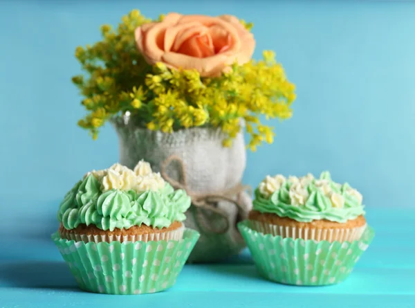 背景色が水色のテーブルに美味しいカップケーキ — ストック写真