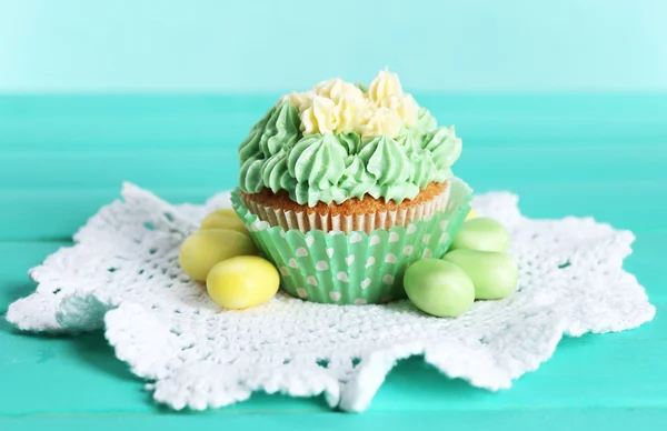 Tasty cupcake on table, on turquoise background — Stock Photo, Image