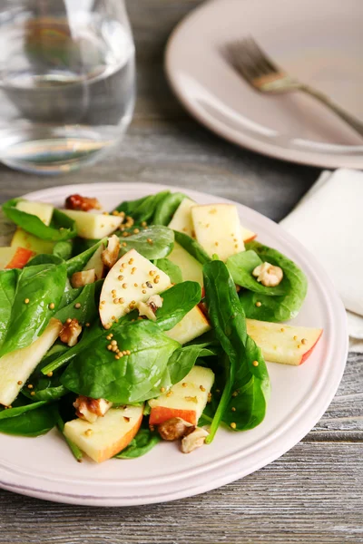 Зеленый салат с яблоками, орехами и сыром на деревянном фоне — стоковое фото