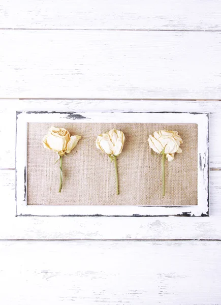 Wooden frame with dried flowers on wooden background — Stock Photo, Image