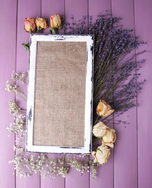 Wooden frame with dried flowers on wooden background — Stock Photo, Image