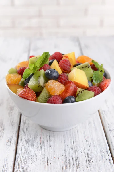 Köstlicher Obstsalat im Teller auf dem Tisch in Großaufnahme — Stockfoto