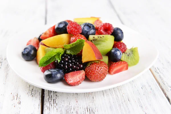 Köstlicher Obstsalat im Teller auf dem Tisch in Großaufnahme — Stockfoto