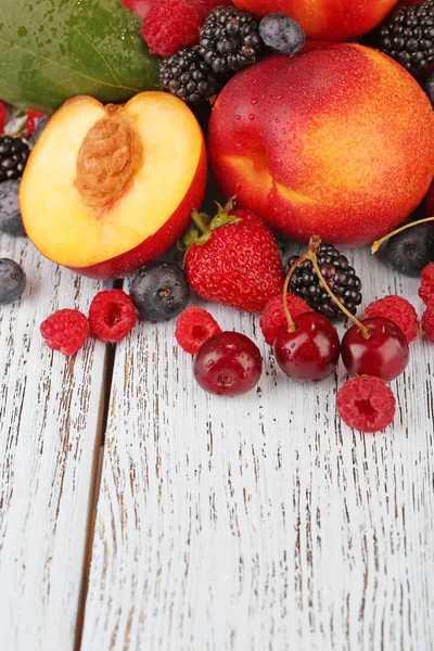 Peaches with berries on table — Stock Photo, Image