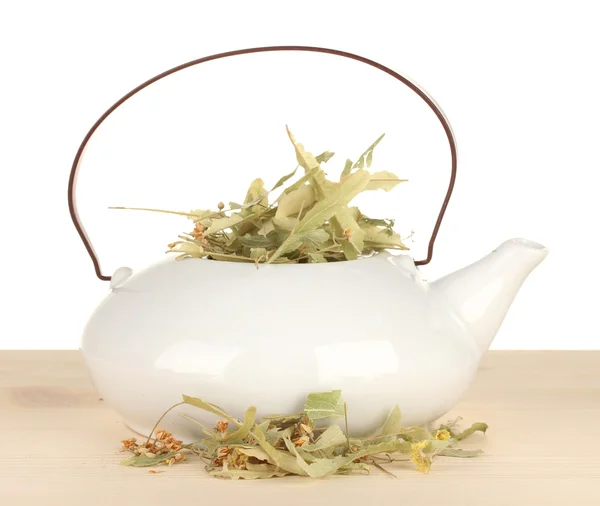 Сушеные травы в чайнике на деревянном столе, изолированные на белом. Концептуальное фото травяного чая . — стоковое фото