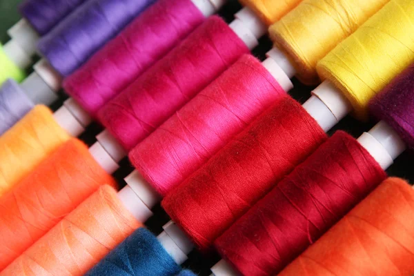 Multicolor sewing threads on wooden background — Stock Photo, Image