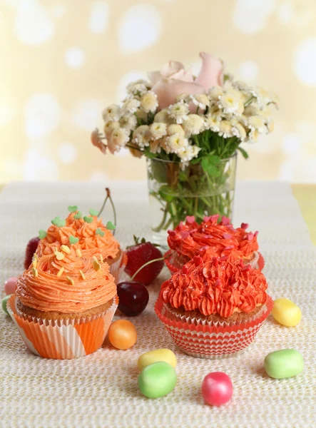 Cupcakes saborosos na mesa, no fundo brilhante — Fotografia de Stock