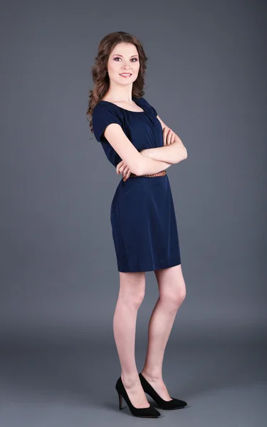 Schöne junge Mädchen im Kleid auf grauem Hintergrund — Stockfoto