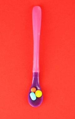 plastik kaşık kırmızı arka plan rengi hapları ile