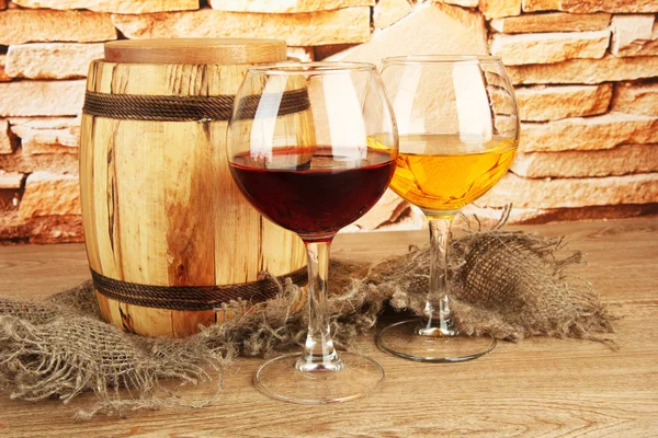 Composición de vino y barril de madera en la mesa sobre fondo de pared de ladrillo —  Fotos de Stock