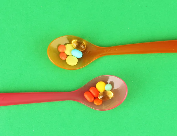 Plastic spoons with color pills — Stock Photo, Image