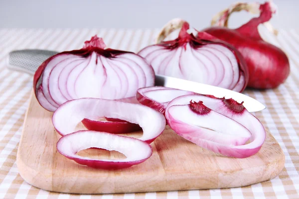 Cebollas rojas frescas en la tabla de cortar de cerca — Foto de Stock