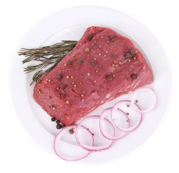 Ruwe rundvlees met kruiden op plaat geïsoleerd op wit — Stockfoto