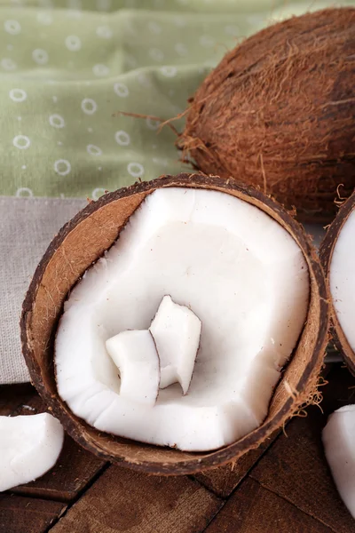 Broken coconut with napkin on wooden background — Stock Photo, Image