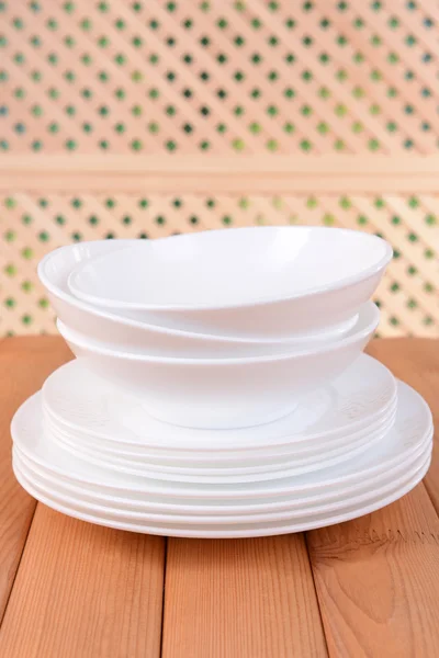 Set de platos blancos sobre mesa sobre fondo claro — Foto de Stock