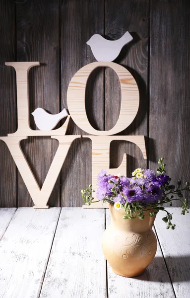 Lettres décoratives formant mot AMOUR avec des fleurs sauvages sur fond en bois — Photo