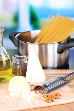 makarna hazırlama işlemi. pan, rende, peynir, parlak zemin üzerine ahşap tablo içinde satır spagetti ile kompozisyon