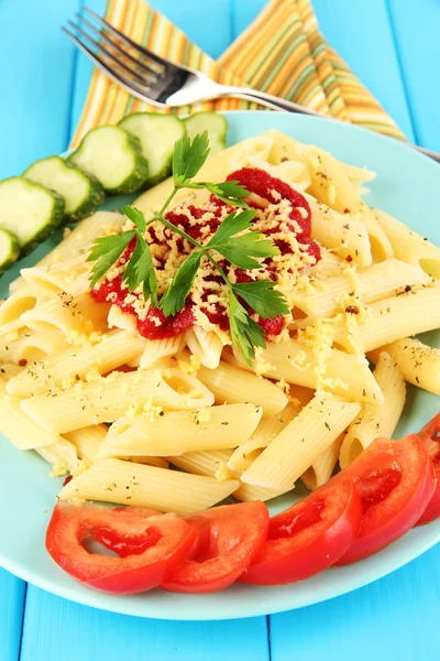 Rigatoni pasta dish with tomato sauce on blue wooden table — Stock Photo, Image