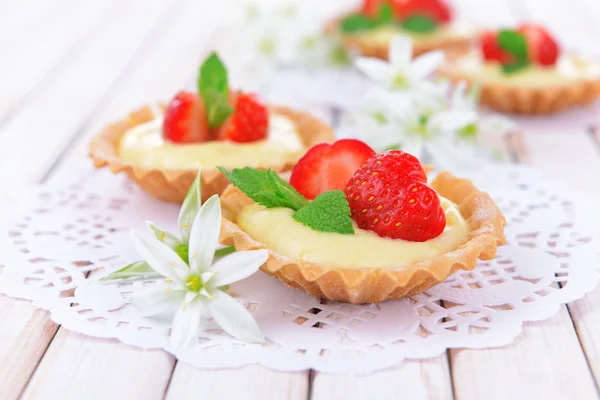 Smakelijke tartlets met aardbeien op tabel close-up — Stockfoto