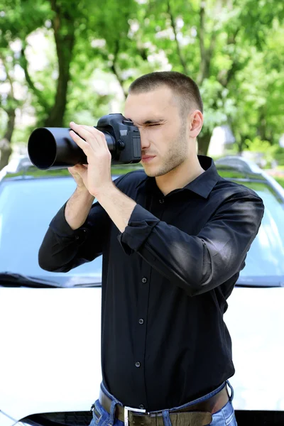 Hombre cerca de coche con cámara fotográfica —  Fotos de Stock