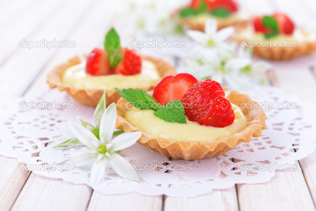 Tasty tartlets with strawberries on table close-up