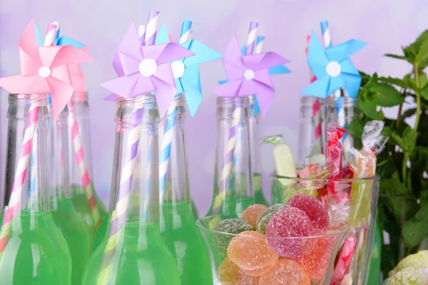 Bottiglie con bevande e dolci — Foto Stock