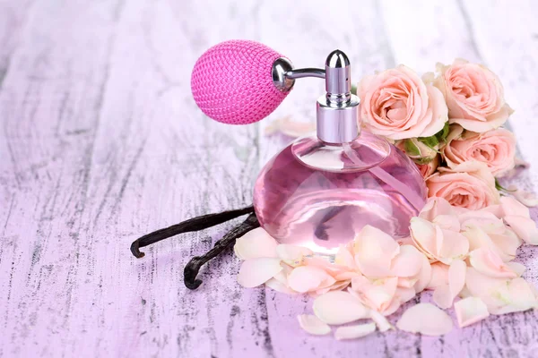 Perfume bottle with roses petals — Stock Photo, Image