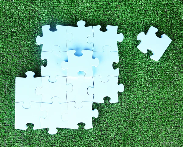 푸른 잔디에 조각 퍼즐 — 스톡 사진