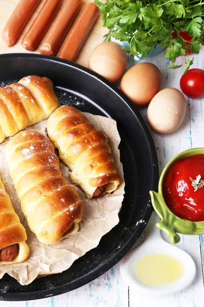 Baked sausage rolls in pan on table close-up — Stock Photo, Image