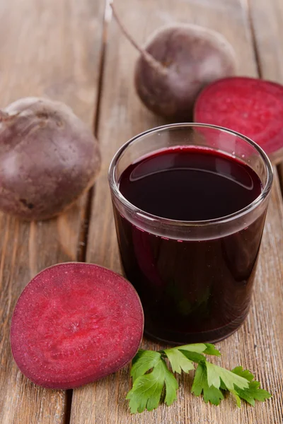 Glass of fresh beet juice and vegetables on wooden background — Stock Photo, Image