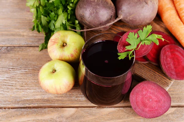 Vaso de jugo de remolacha fresca y verduras sobre fondo de madera — Foto de Stock